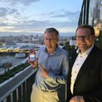 Jerome presents a mobile phone receiving 5G Broadcast on a rooftop terrace in Paris togehter with Johann